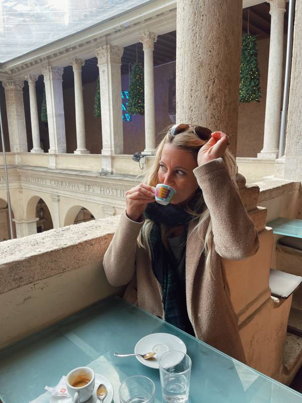 Jenn sipping espresso in a Roman courtyard